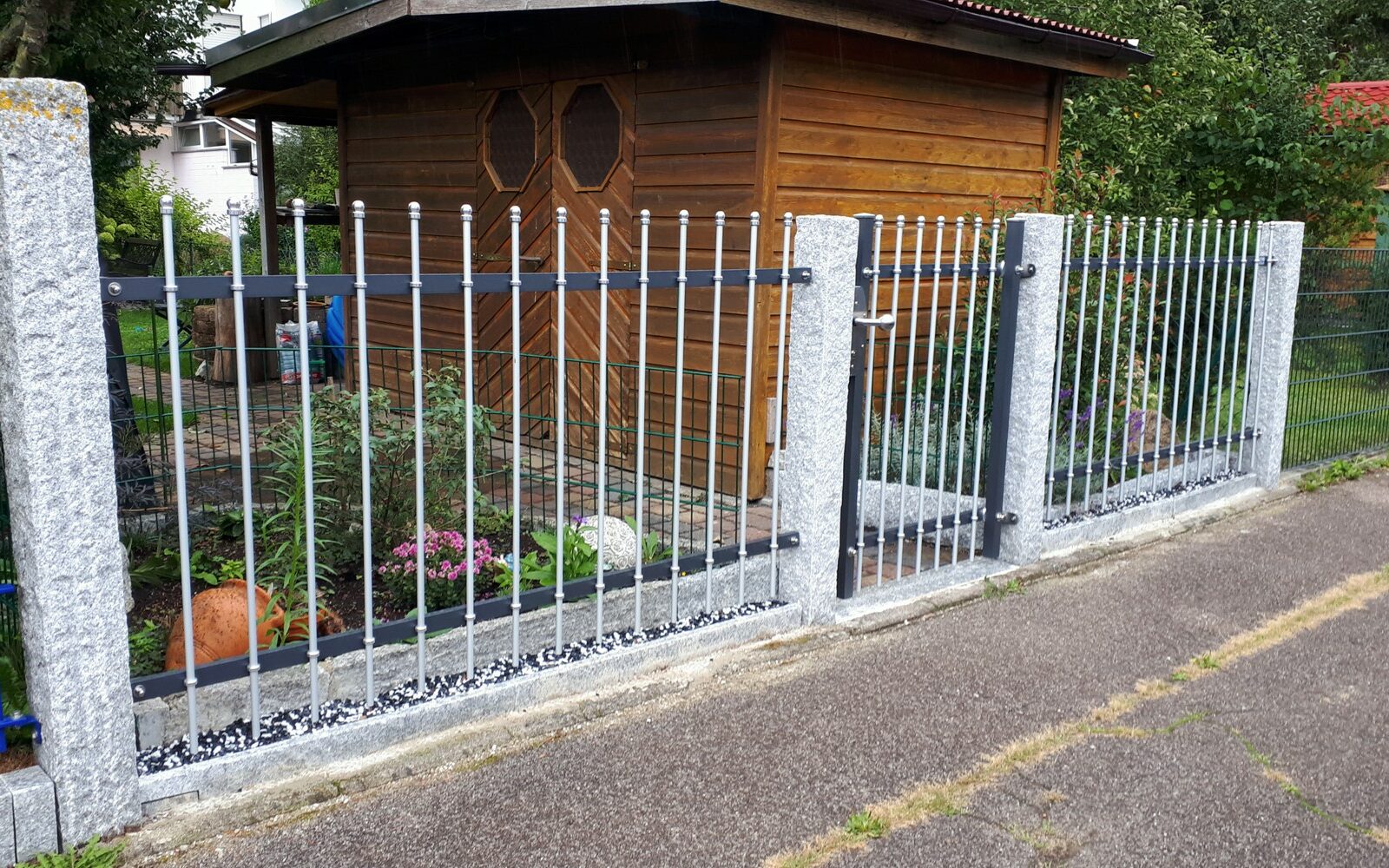 Der moderne Zaun BRILLANT in 2-farbigem Design passt auch gut zu rustikalen Granitstehlen
